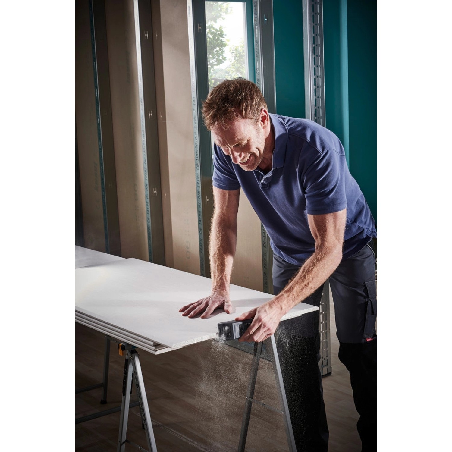 Mann benutzt wolfcraft Blockhobel (150x57mm) auf Gipskartonplatte. Hobel für Trockenbau und Holz.