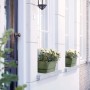Elho Greenville Blumenkasten in Laubgrün auf Fensterbank mit weißen Blumen.