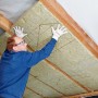 Ein Mann verlegt Rockwool Klemmrock Dämmwolle (120mm) zur Dachisolierung.