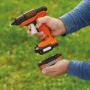 Black+Decker Akku-Heißklebepistole BDCGG12N 12 V mit Akku in Hand vor grünem Hintergrund.