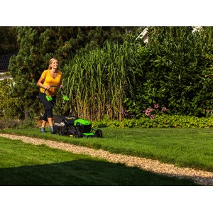 Greenworks Akku-Rasenmäher GD40LM46SPK4 im Einsatz: Frau mäht Rasen mit dem Akku-Mäher Set.