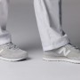 Graue New Balance 515 SR Berufsschuhe für Herren, Größe 40, getragen mit weißer Hose.