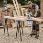Mann sägt Holz auf zwei blauen HOMCOM Metall-Sägeböcken. Robuste, klappbare Arbeitsböcke mit EVA-Polsterung für Bauarbeiten.