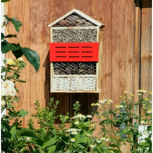 Holz Insektenhotel 5 Sterne mit roter Blende, gefüllt mit Naturmaterialien, an einer Holzwand.