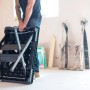 Zusammengeklappte Stanley FatMax Werkbank (85x60cm) wird von einer Person getragen.