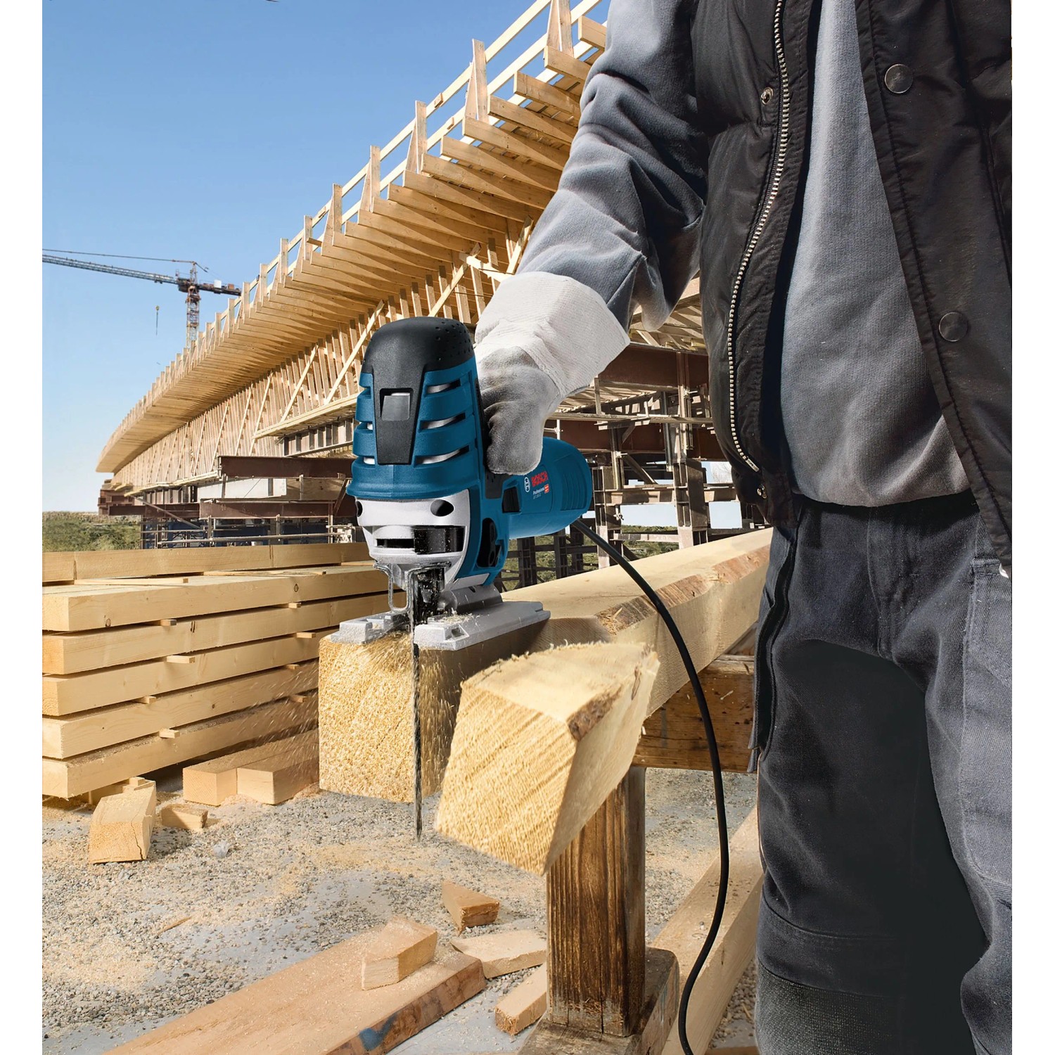 Handwerker sägt mit Bosch Professional Stichsäge GST 150 CE einen Holzbalken präzise auf Baustelle.