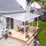 Weiße Palram Olympia Terrassenüberdachung 3x5.5 m mit klarem Dach auf Terrasse mit Tisch und Stühlen.