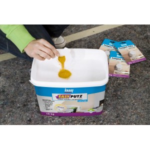 Knauf Compact Color Terracotta Farbpigment wird in einen Eimer EasyPutz gegeben.