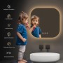 Quadratischer Emke LED-Badspiegel 60x60 cm mit abgerundeten Ecken und warmem Licht. Kind putzt Zähne. Mit Antibeschlag und einstellbarem Licht.