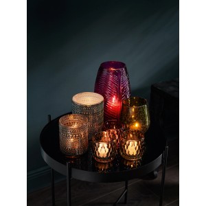 Verschiedene Teelichthalter der Serie Dark Wonder in Magenta, Gold und Silber auf einem Tisch.