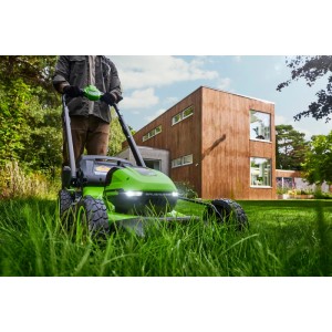 Greenworks Akku-Rasenmäher 2520007UD Gen 2 mit Akkus und Ladegerät im Einsatz auf Rasenfläche.