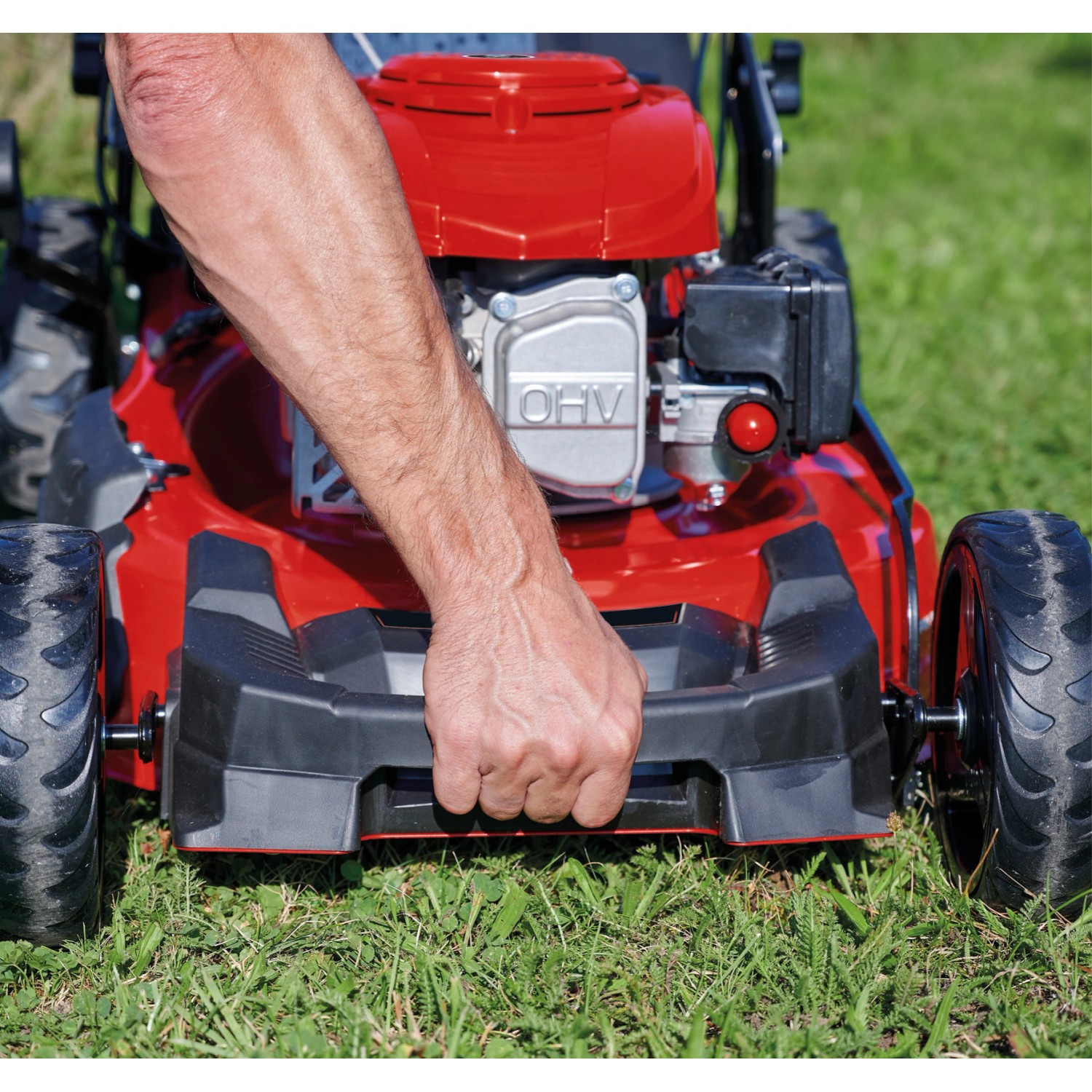 Einhell GC-PM 51/3 S HW-E Benzin-Rasenmäher in Rot, Hand am Griff auf Rasen.