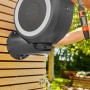 Gardena Wand-Schlauchbox RollUp S mit 15m Schlauch an Holzwand, mit Gartenschlauch und Spritze in der Hand.