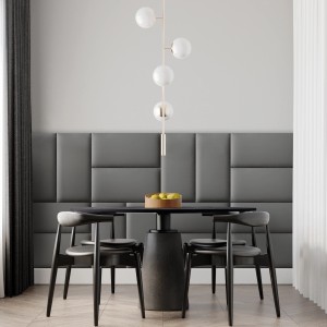 Graue Wandkissen in Lederoptik als Wandpaneel hinter Esstisch mit Stühlen und Lampe.