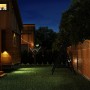 Sichtschutzzaun Element Bordeaux pinienfarben, 180x120/90 cm, im Garten bei Nacht.