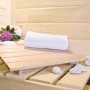 Innenansicht Karibu Sauna-Set Cleo mit Liegefläche, Handtuch und Dekoration.