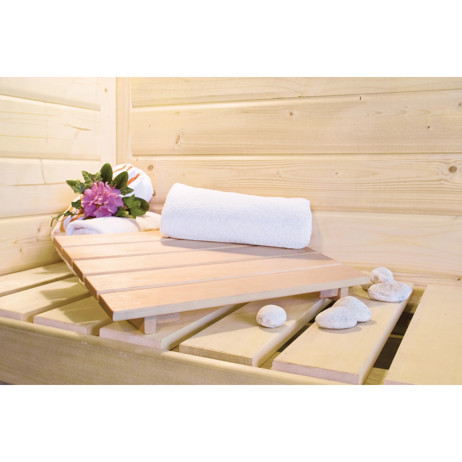 Innenansicht Karibu Sauna-Set Cleo mit Liegefläche, Handtuch und Dekoration.