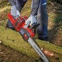 Einhell Akku-Kettensäge GP-LC 36/35 beim Sägen eines Baumstamms im Wald.