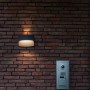 Moderne Lutec LED-Außenwandleuchte Lotus in Anthrazit an einer Backsteinwand.