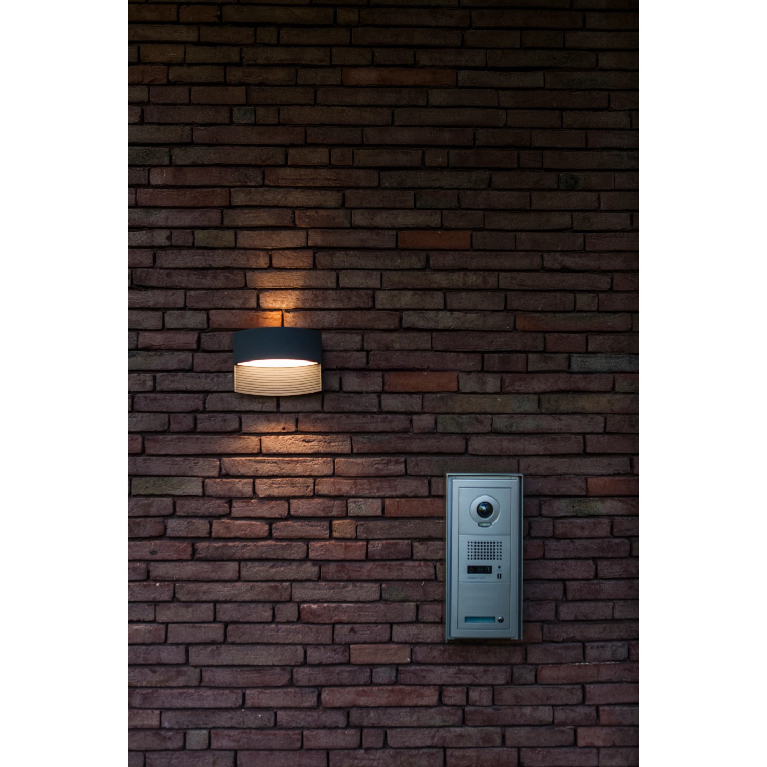 Moderne Lutec LED-Außenwandleuchte Lotus in Anthrazit an einer Backsteinwand.