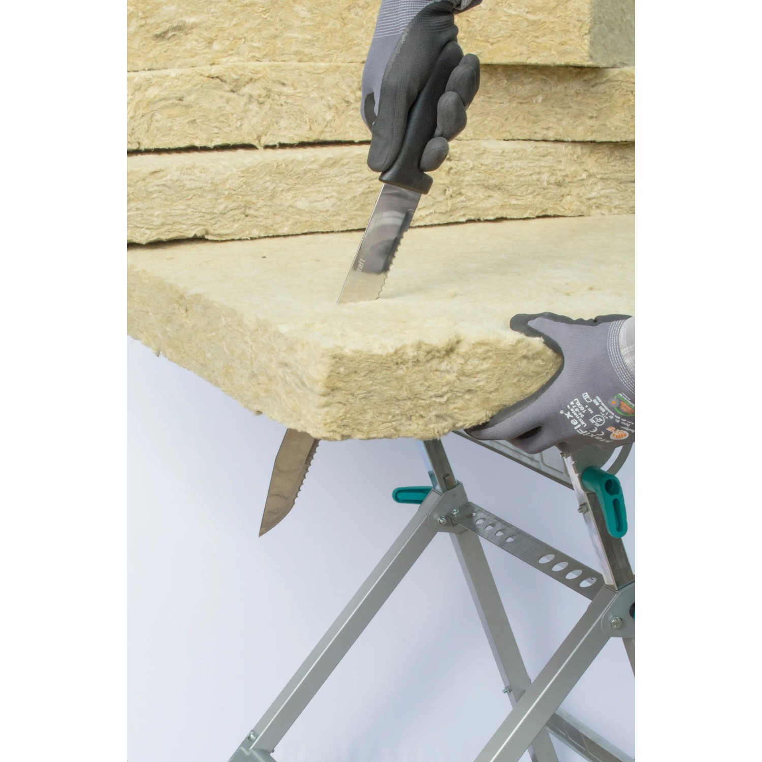 Wolfcraft Dämmstoffmesser schneidet Dämmmaterial auf einem Tisch. Profi-Werkzeug mit 305 mm Klinge.