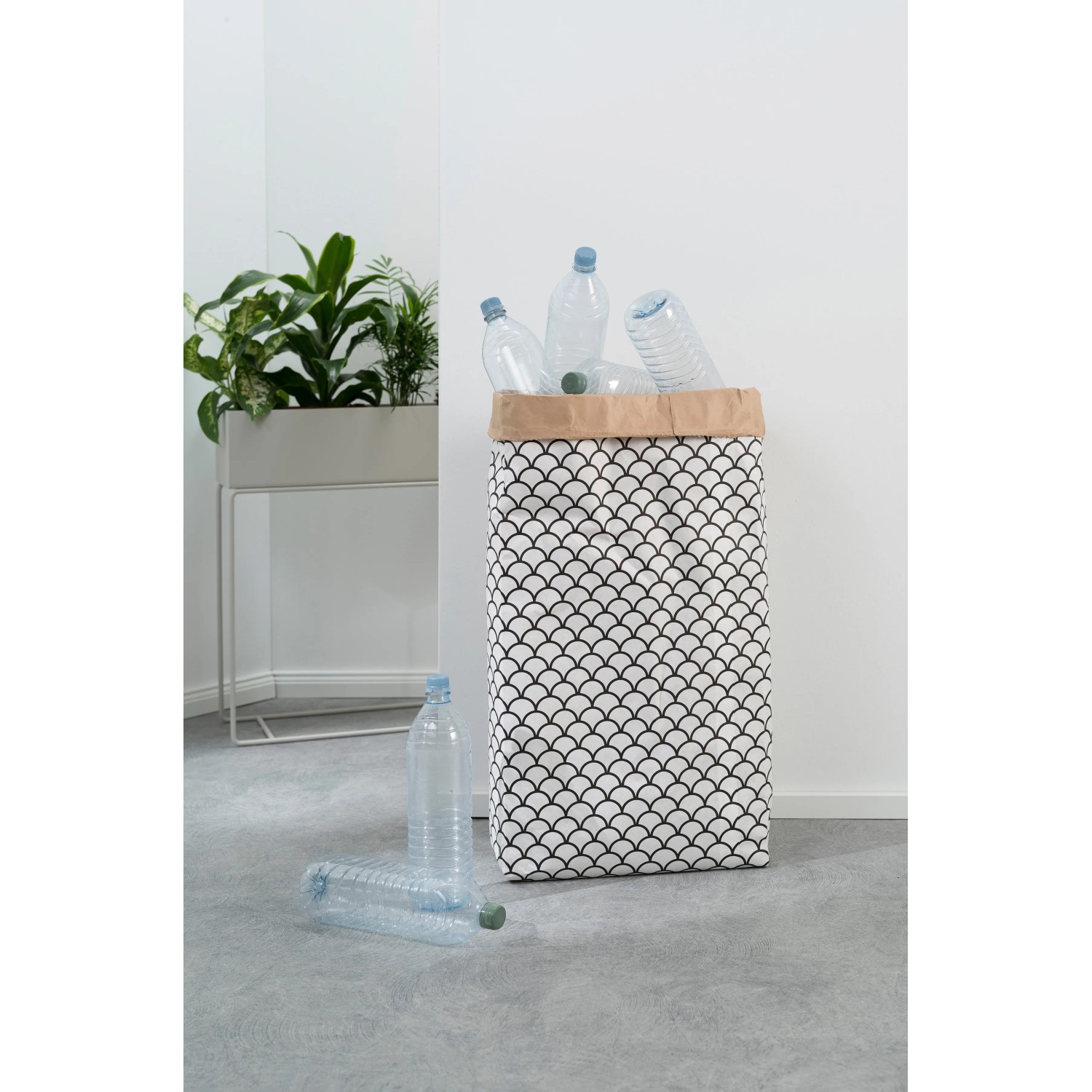 Weißer Sitting Point Sitzsack (60l) mit schwarzem Muster und Papierrand, gefüllt mit PET-Flaschen.
