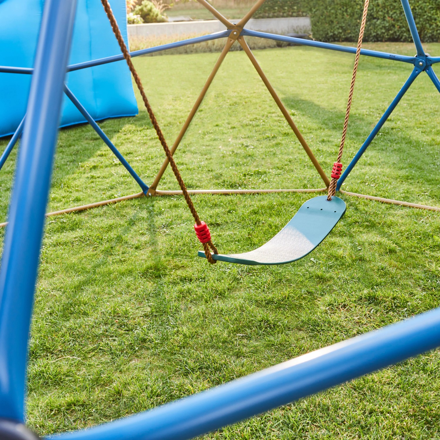Blau-bronze Klettergerüst Matti mit Schaukel und Zelt im Garten.