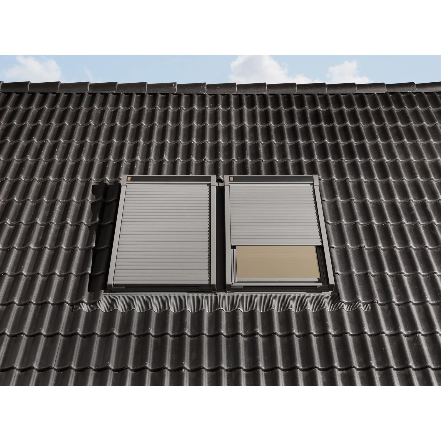 Elektrischer Alu-Rolladen CK04 für Dachfenster, geschlossen und teilweise geöffnet auf einem Dach.