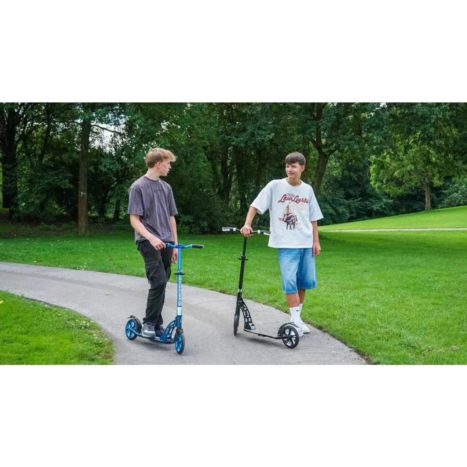 Türkiser Six Degrees Aluminium Scooter mit Klappmechanismus und Ständer auf Parkweg, ein Jugendlicher steht daneben. Ideal für Sport & Freizeit.