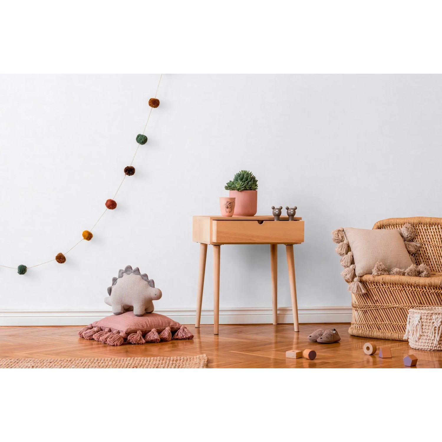 Kinderzimmer mit weißer Uni-Tapete, Holztisch und Deko-Elementen.