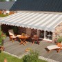 Beige-sandfarbene Spettmann Halbkassettenmarkise Sky Klassik (250x200 cm) über einer Terrasse mit Gartenmöbeln.