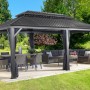 Sojag Aluminium Pavillon Messina 12x20 Anthrazit mit Möbeln und Moskitonetz im Garten.