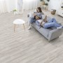 Heller Wohnraum mit Kaindl Laminat Eiche Historic Arctic, Paar auf Sofa.