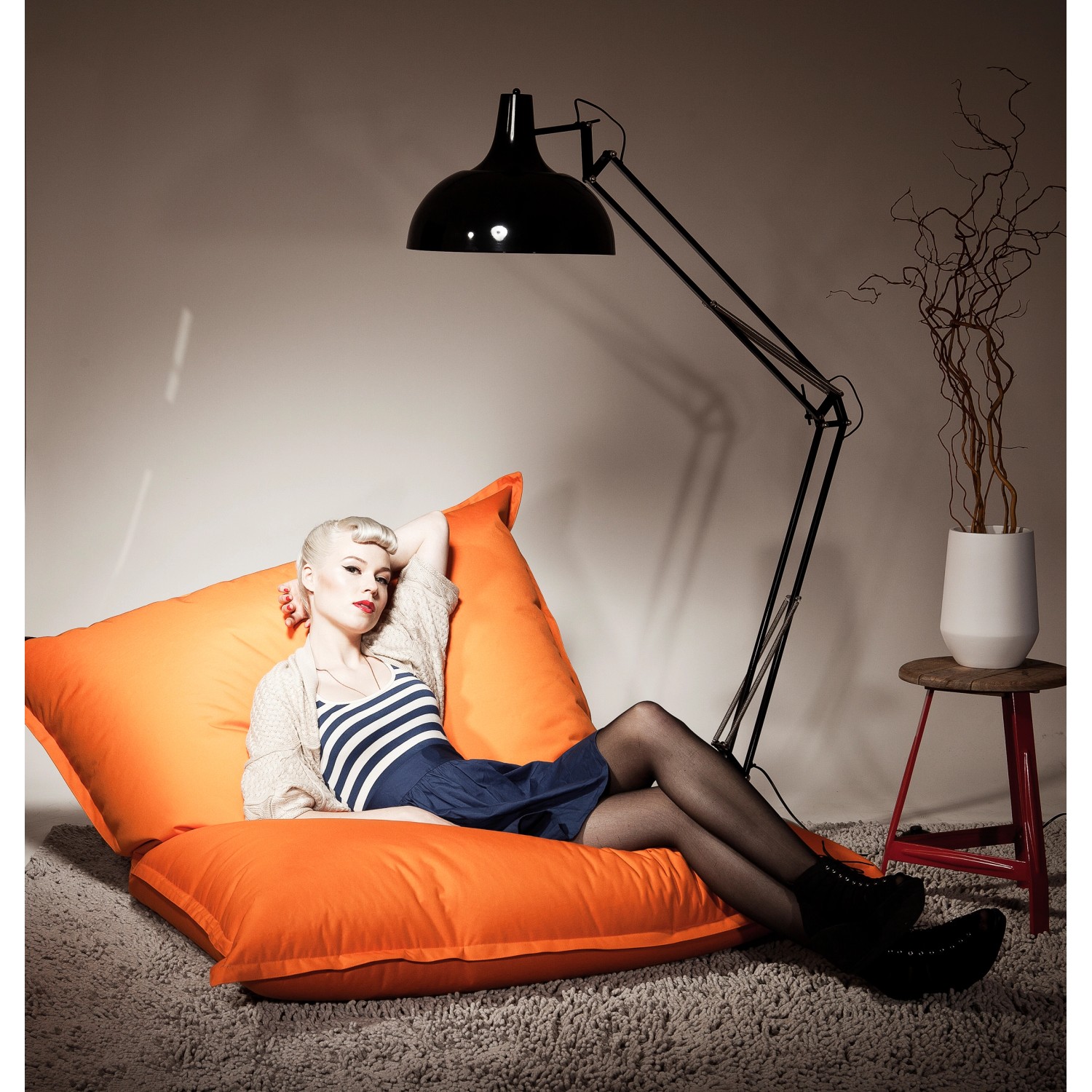 Frau entspannt auf orangefarbenem Sitting Point Big Foot Sitzsack (380 l).