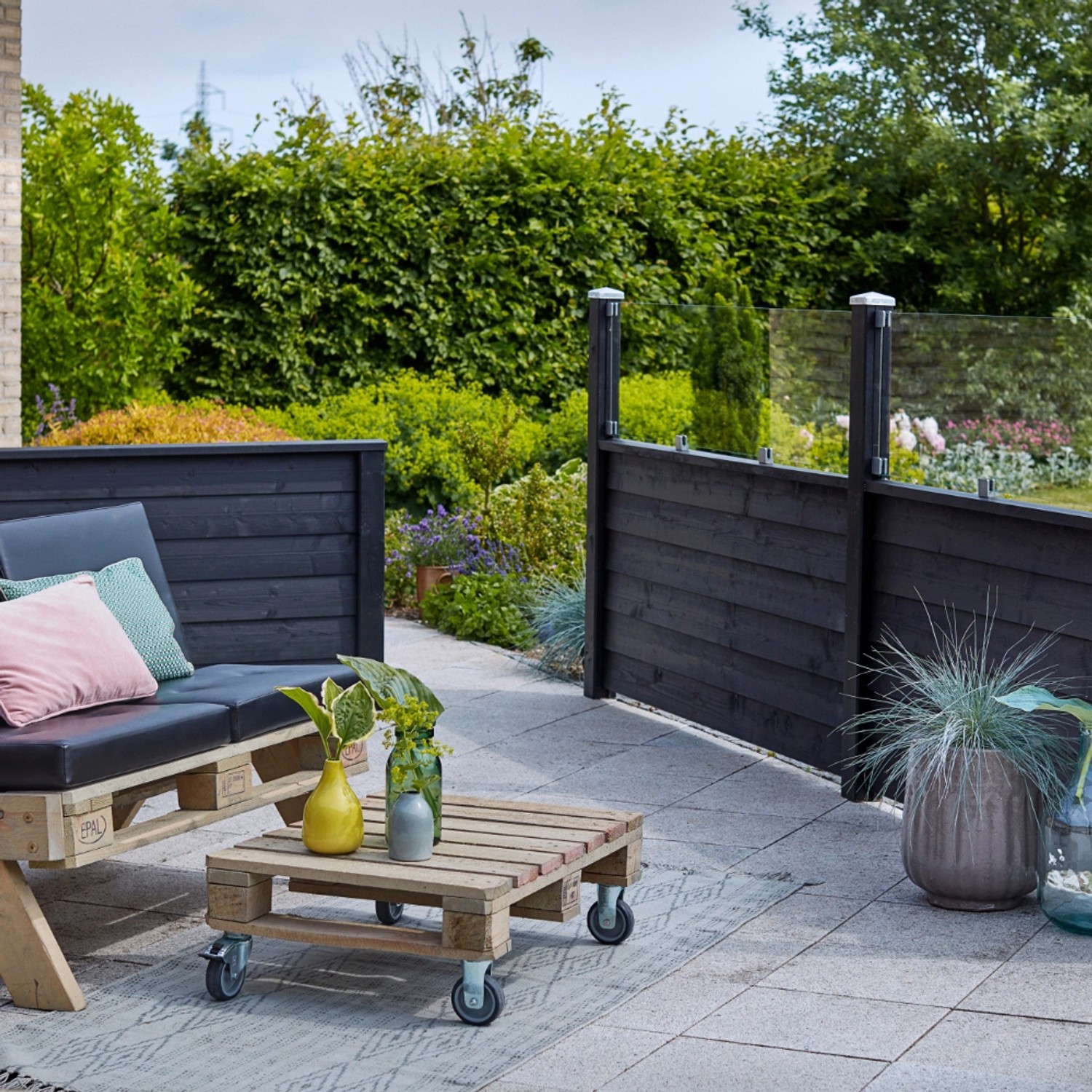 Schwarzer Sichtschutzzaun Klink aus Nadelholz, 174x91cm, im Garten mit Lounge-Möbeln.