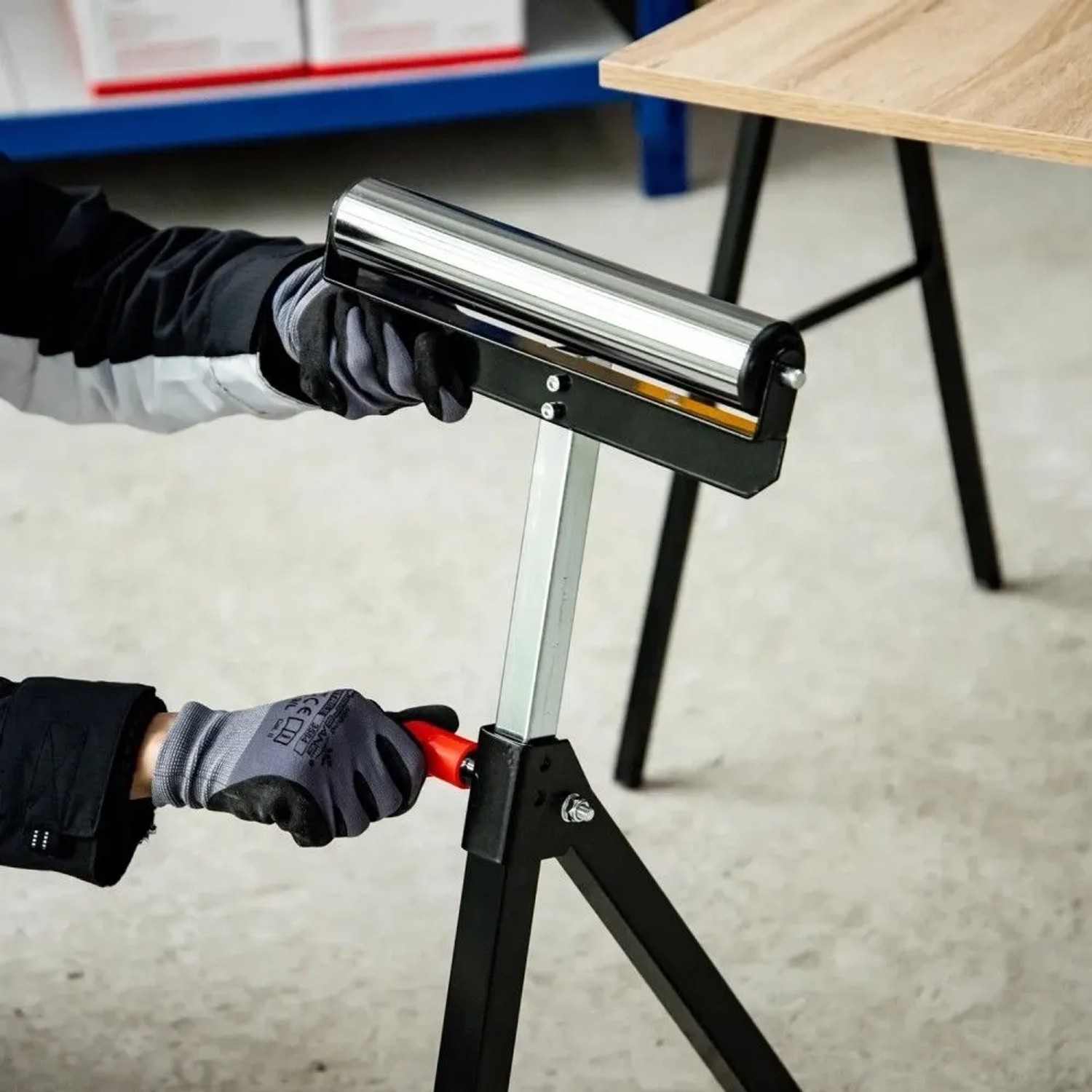 Person justiert schwarzen, höhenverstellbaren HOMCOM Rollenbock aus Metall mit silberner Rolle für Holzbearbeitung.