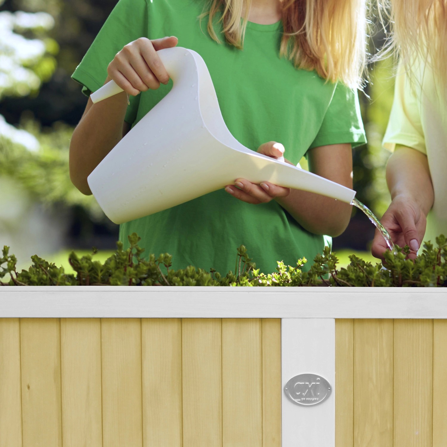 Kind gießt Pflanzen im braun-weißen Axi Hochbeet 120x54x90 cm mit Gießkanne.