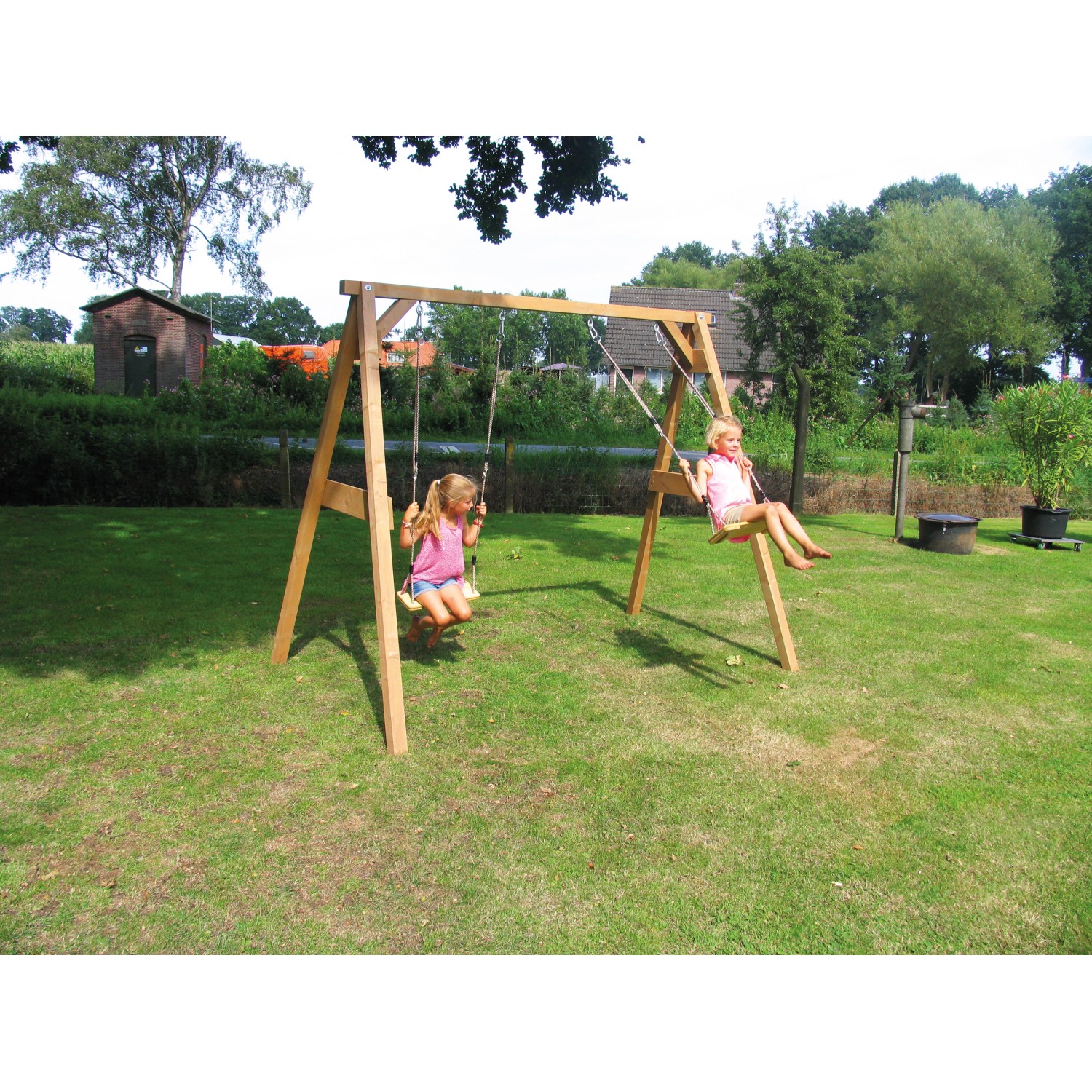 Axi Doppelschaukel aus Holz mit zwei Kindern im Garten.