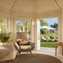 Innenansicht: Palmako Holz-Pavillon Veronica 7 mit Fenstern und Einrichtung im Garten.
