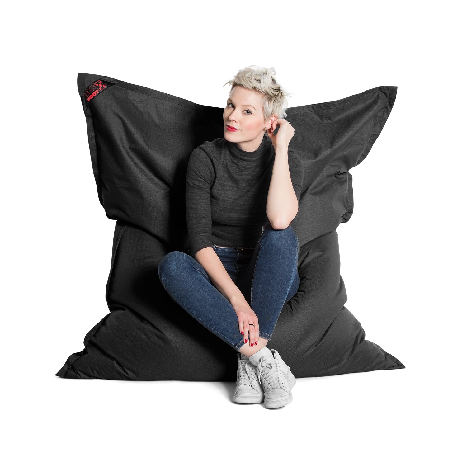 Schwarzer Sitting Point Sitzsack Big Foot Scuba (380 l) mit sitzender Person.