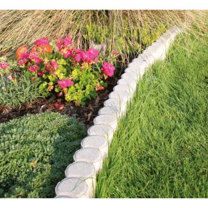 Graue Duopal Doppelpalisade als Beeteinfassung im Garten, umrandet Blumen und Rasen.