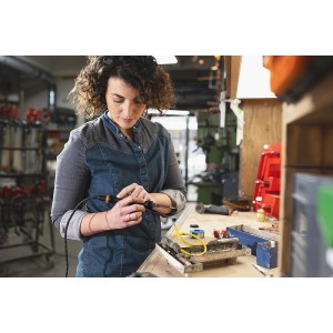 Frau bedient Worx MakerX Akku-Lötkolben WX744.9 zum Löten/Brandmalen in Werkstatt.