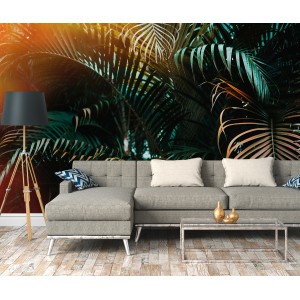 Fototapete mit Palmenblättern in Grün, Gelb und Orange hinter einem Sofa. Tropisches Flair für Ihr Zuhause.