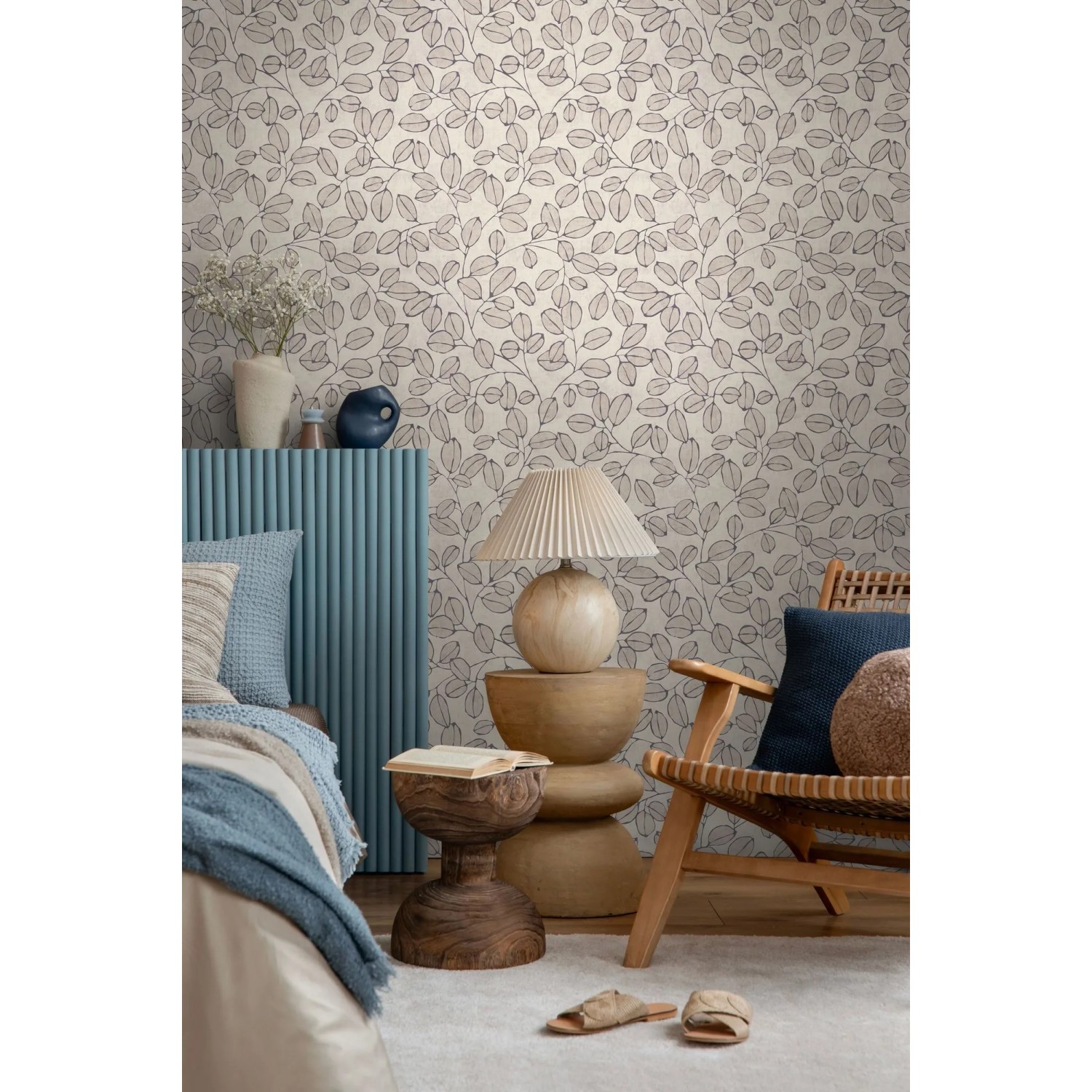 Vliestapete 'Blätter Grau Weiß' mit floralem Muster in skandinavischem Stil, an einer Wand im Wohnzimmer.