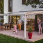 Weiße Terrassenüberdachung Genua aus Aluminium mit Polycarbonat-Doppelstegplatten und Familie.