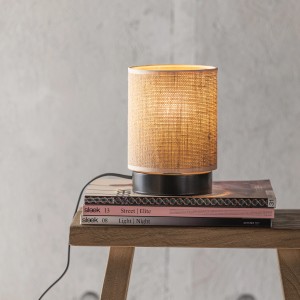 Brilliant Tischleuchte Aniela, schwarz-naturfarben, mit Textilschirm auf Büchern.