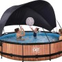 EXIT Wood Pool, braun, ø 360 cm mit Sonnensegel und Familie im Wasser.