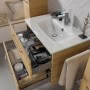 Pelipal Glas-Waschbecken Trentino 77 cm mit Unterschrank und offenen Schubladen.