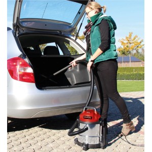 Frau saugt mit Einhell Nass-Trockensauger TC-VC 1815 S Kofferraum eines Autos.