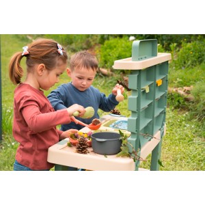 Kinder spielen mit der Smoby Matschküche Life Bunt im Garten, mit Zubehör und viel Spaß.